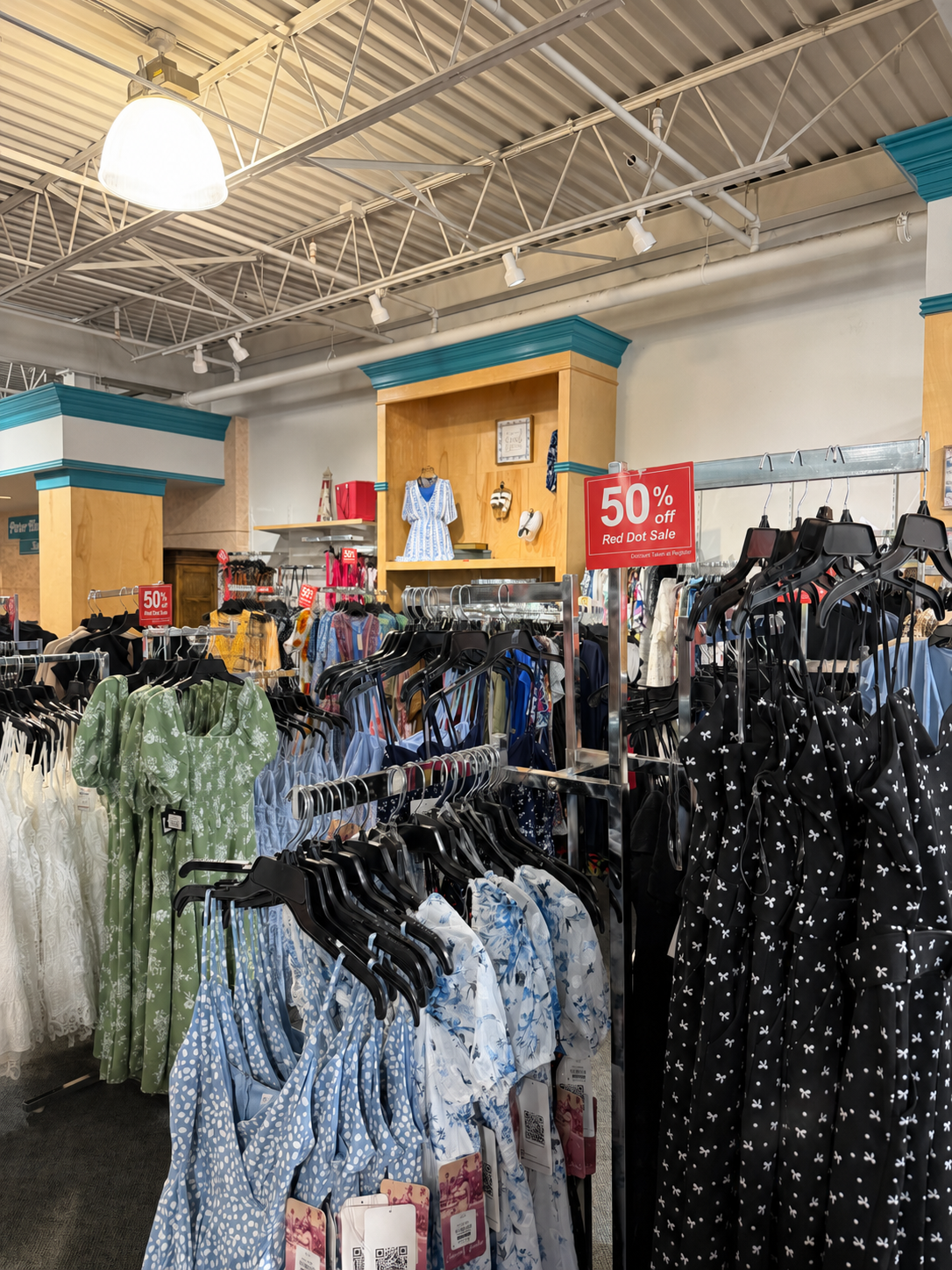 Clothing racks inside Label Shopper with 50% off red sign