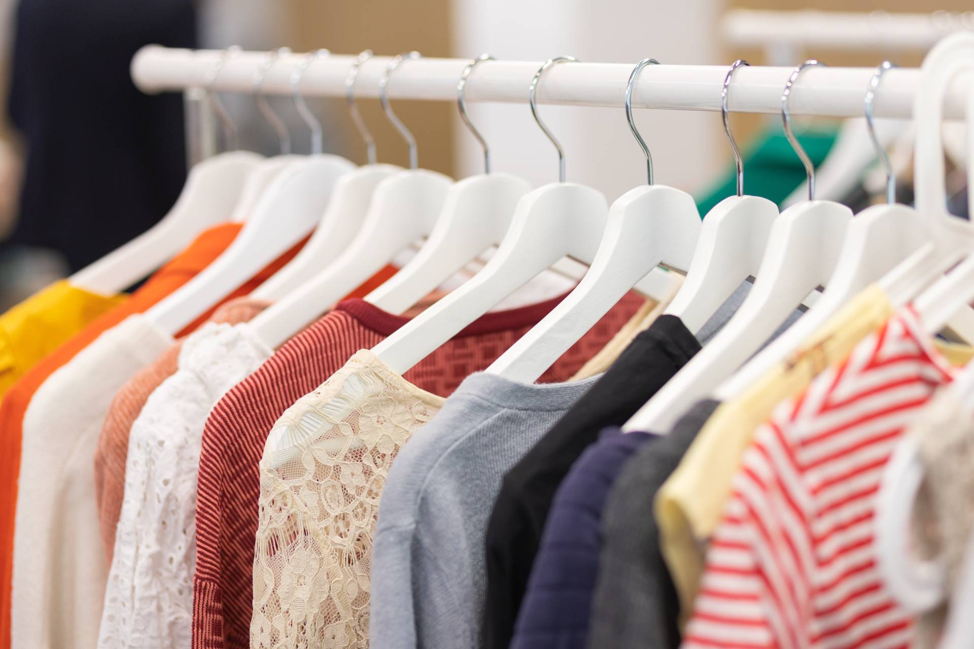 Colorful t-shirts on a clothing rack in a Label Shopper store.