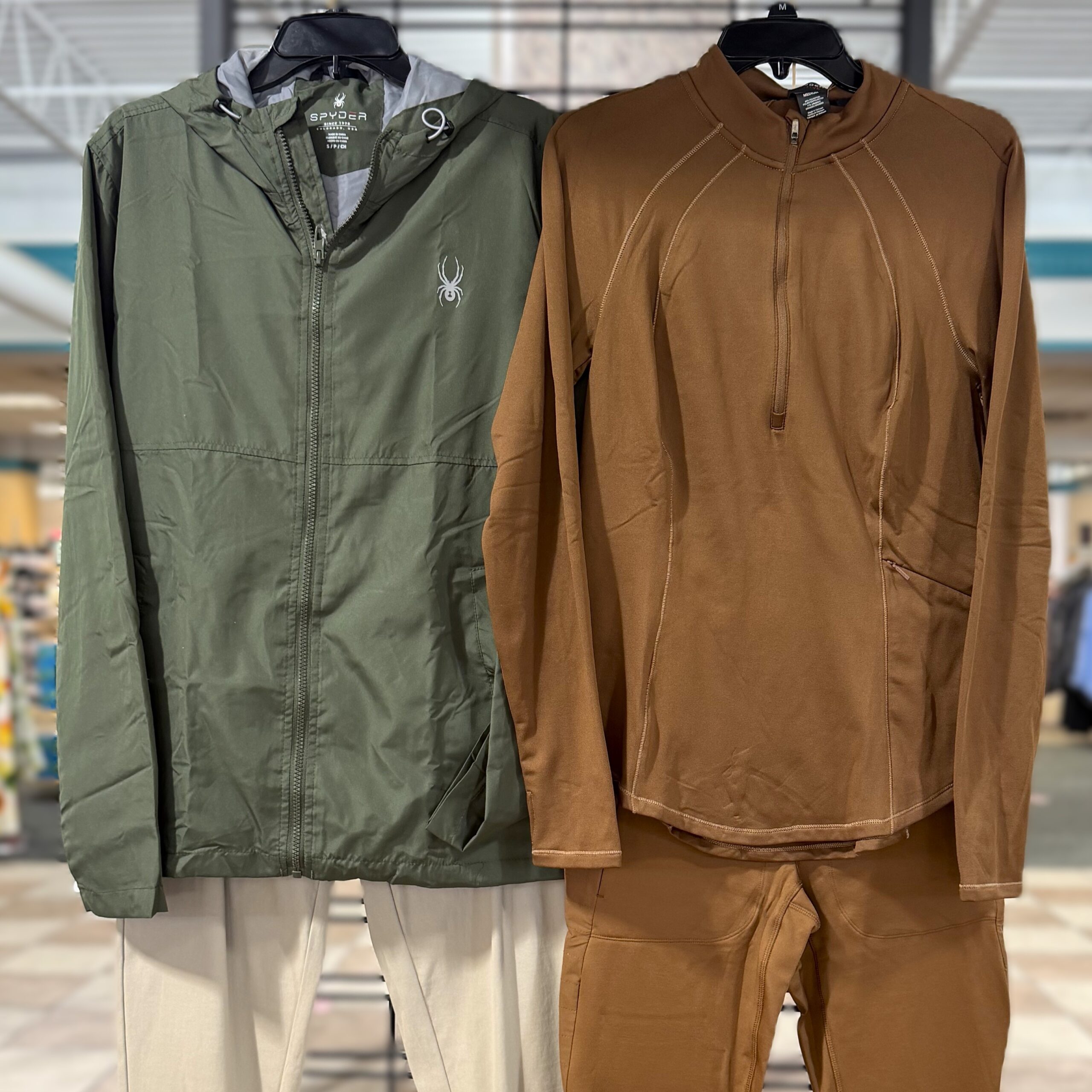 Image of two hiking outfits hanging on racks next to each other
